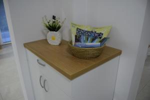 a shelf on a cabinet with books and a vase of flowers at Apartma Šmarnica in Slap ob Idrijci