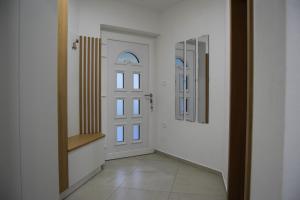 a hallway with a white door and a mirror at Apartma Šmarnica in Slap ob Idrijci