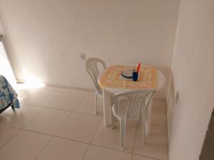 a small white table with two chairs in a room at Angelsuites in Maceió