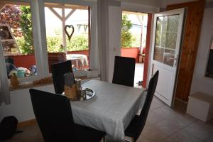 a dining room with a table and chairs and a door at Ferienhaus Abendrot in Basedow +7 photos