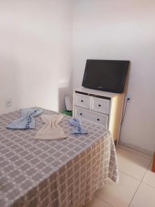 a bedroom with a bed and a flat screen tv at Angelsuites in Maceió