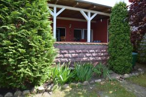 a house with a brick wall and trees at Ferienhaus Abendrot in Basedow