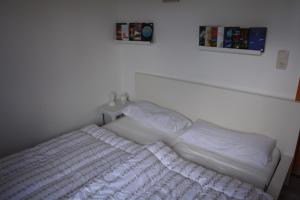 a white bed in a white room with a white bedspread at Ferienhaus Abendrot in Basedow