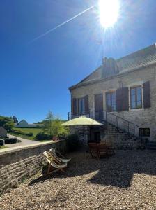 a house with a table and an umbrella in front of it at Gîte de l 'Angeline in Bissey-sous-Cruchaud
