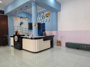 a woman sitting at a counter in a waiting room at Jason Residencia One Hotel in Phnom Penh