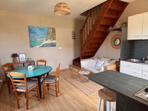 a kitchen and living room with a table and chairs at Camping Les Pommiers in Sotteville-sur-Mer +26 photos