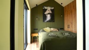 a bedroom with green walls and a bed with two pillows at Bárucottage in Eyrarbakki