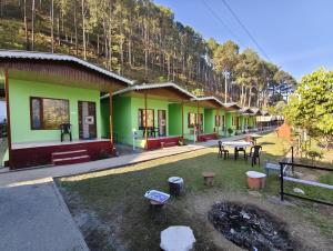 a row of houses with a table and chairs at DJSR Resort in Barkot