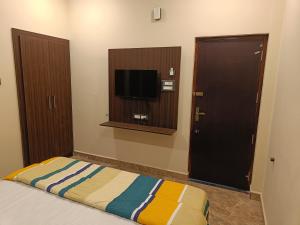 a bedroom with a bed and a flat screen tv at PVR Grand Residency in Tiruvannāmalai