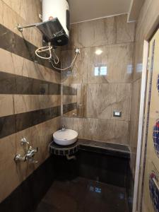 a small bathroom with a sink and a toilet at PVR Grand Residency in Tiruvannāmalai