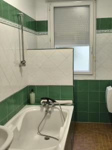 a green and white bathroom with a tub and a sink at Aubrion de Cremens in Magnan