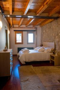 a bedroom with two beds and a stone wall at Ca la Bepa in Rocafort de Vallbona
