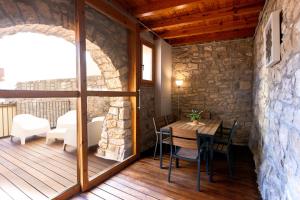 a room with a wooden table and chairs on a deck at Ca la Bepa in Rocafort de Vallbona