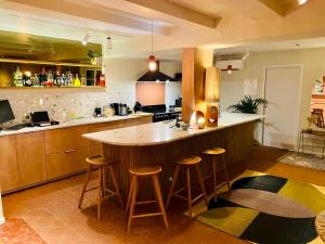 a kitchen with a large island in a kitchen with stools at Le Jardin d'Emile in Cassis