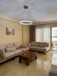 a living room with a couch and a coffee table at Azure Dream Apartment in Durrës +52 photos