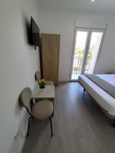 ein Schlafzimmer mit einem Bett und einem Tisch mit einem Stuhl in der Unterkunft Nbm in Puerto de Gandía