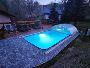 a swimming pool with a tent on a patio at Apartmá Gister ski and wellnes in Rokytnice nad Jizerou