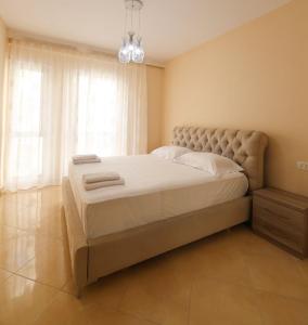 a large bed in a bedroom with a window at Azure Dream Apartment in Durrës