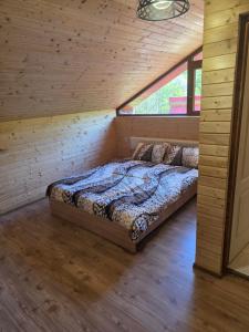 a bedroom with two beds in a wooden cabin at Casa Tudor - Râul Mare Retezat in Clopotiva