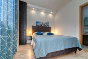 a bedroom with a large bed with blue pillows at Bella Casa in Sukošan