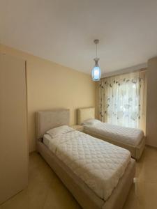 a bedroom with two beds and a window at Azure Dream Apartment in Durrës