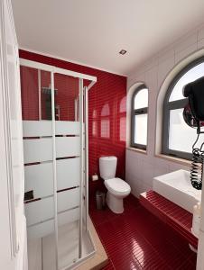 a red bathroom with a toilet and a sink at Hotel Santa Eulália Bay - Adults Only in Albufeira +30 photos