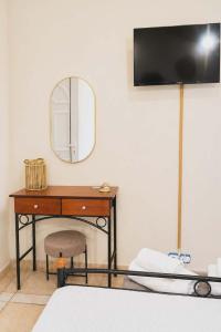 a bedroom with a desk with a mirror and a chair at Pantelis Studio in Paralia Agias Foteinis