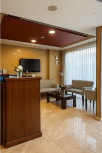 a living room with a couch and a tv at Al Amer Palace Hotel in Amman