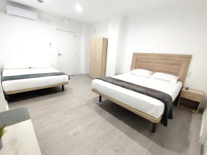 ein Schlafzimmer mit zwei Betten und einem Fenster in der Unterkunft Nbm in Puerto de Gandía