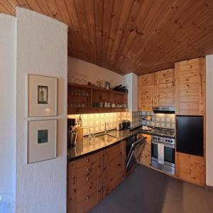 a kitchen with wooden cabinets and a counter top at Alpen-Retreat mit Spa in Lenzerheide