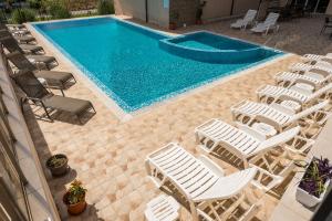 an overhead view of a swimming pool with chairs and a swimming pool at Киво апарт Созопол in Sozopol