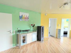 a room with a table and a refrigerator in it at Ferienwohnung Eifeltraum in Masburg +1 photo