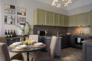 a kitchen with green cabinets and a table with chairs at Altarocca Embassy Rome in Rome