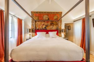 a bedroom with a large bed with a painting on the wall at Manoir Des Douets Fleuris in Cancale +137 photos