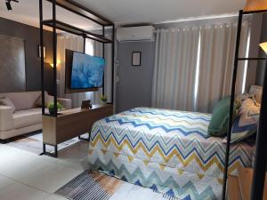 a bedroom with a bunk bed and a living room at Studio Elegante - Completo - AC - Garagem in Rondonópolis