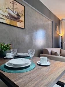 a dining room table with plates and glasses on it at Studio Elegante - Completo - AC - Garagem in Rondonópolis