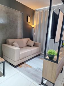 a living room with a couch and a mirror at Studio Elegante - Completo - AC - Garagem in Rondonópolis