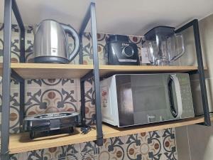 a microwave and a toaster oven on a shelf at Studio Elegante - Completo - AC - Garagem in Rondonópolis +19 photos