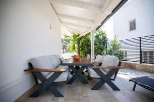 a patio with a table and chairs on a balcony at Noa Suite Hotel Only Adult in Bodrum City