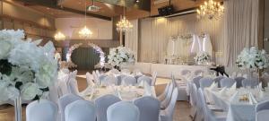 a banquet hall with white tables and chairs and flowers at Hotelli Viikinhovi in Keuruu