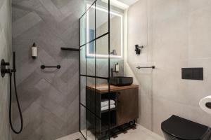 a bathroom with a shower with a sink and a toilet at Butikowy Hotel M23 Katowice Centrum in Katowice