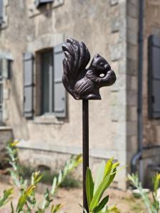 a statue of a bird on a pole in front of a building at Chambres d'hôtes "Le Petit Cardinal" - proche PuyduFou in Mauléon