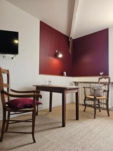 a dining room with a table and a chair at Chambres d'hôtes "Le Petit Cardinal" - proche PuyduFou in Mauléon