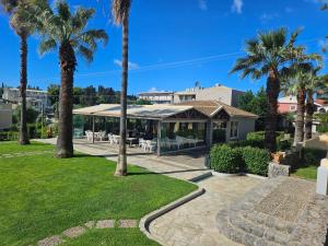 a house with palm trees in a park at Asteraki ApartHotel in Gouvia