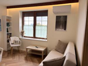 a living room with a couch and a window at Kwietny Stoczek 70 in Białowieża