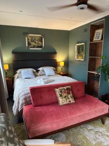 a bedroom with a large bed with a red couch at Greyton Stay in Greyton