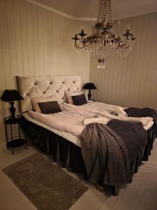 a large bed in a room with a chandelier at Nordgrenska in Åmål