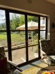an open door to a patio with an umbrella at Greyton Stay in Greyton