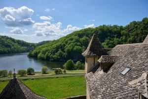 a building with a view of a river and mountains at Castel de Grafeuille in Hautefage +28 photos