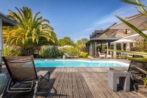 a deck with chairs and a swimming pool at Manoir Des Douets Fleuris in Cancale